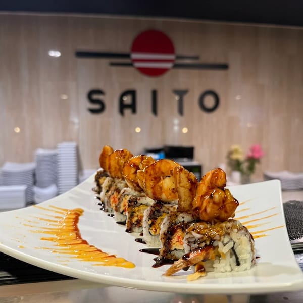 Saito Japanese Steakhouse sushi roll with shrimp tempura, eel sauce, and spicy mayo drizzle.